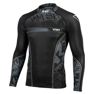 A long-sleeve athletic rash guard in black and dark gray with a subtle graffiti-style graphic pattern, featuring the VNM brand logo on the chest and shoulders, shown against a solid black background.
